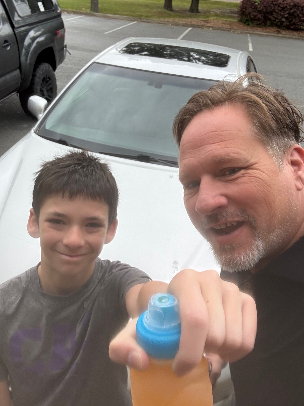 Ryan and Isaac taking a selfie in front of the work van